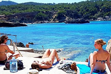 three girls sunbathing at cala xarraca in ibiza