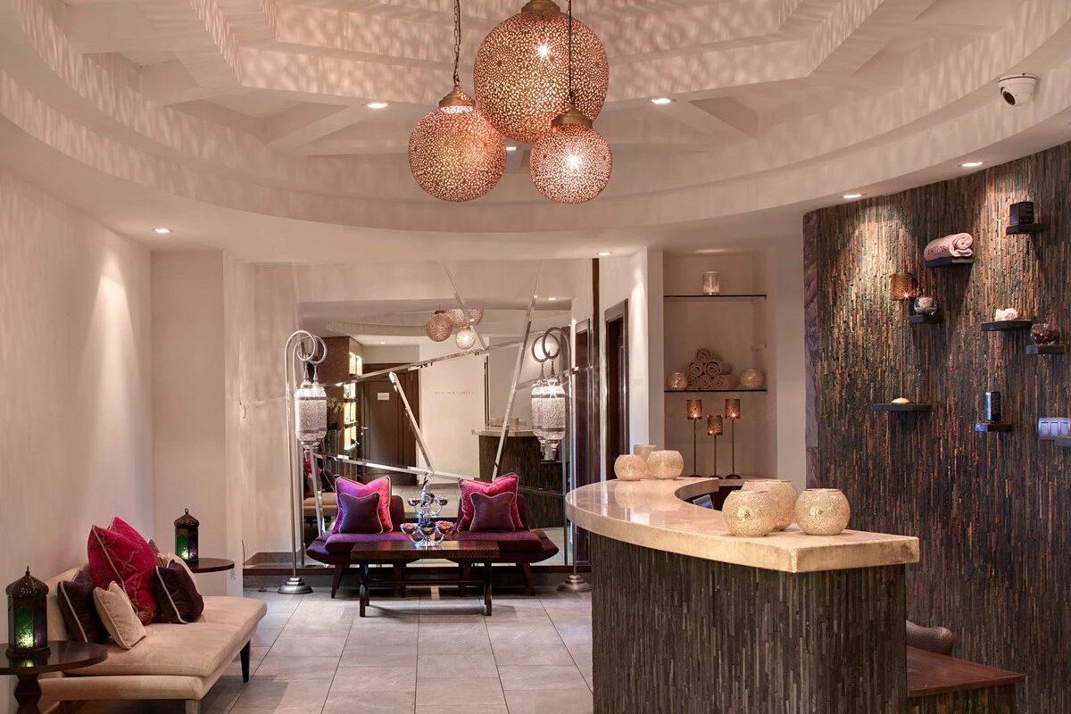 A room with a couch and a counter with lamps hanging from the ceiling