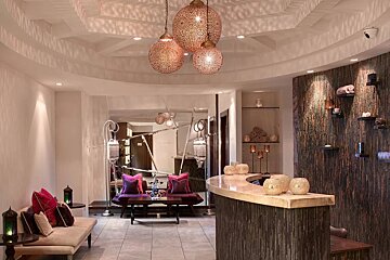 A room with a couch and a counter with lamps hanging from the ceiling