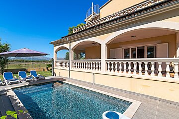 A large house with a swimming pool in front of it