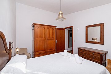 A bedroom with a bed dresser and mirror