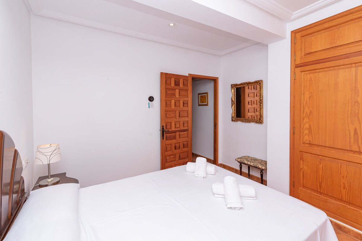 A bedroom with a bed and a mirror on the wall