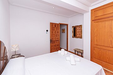 A bedroom with a bed and a mirror on the wall