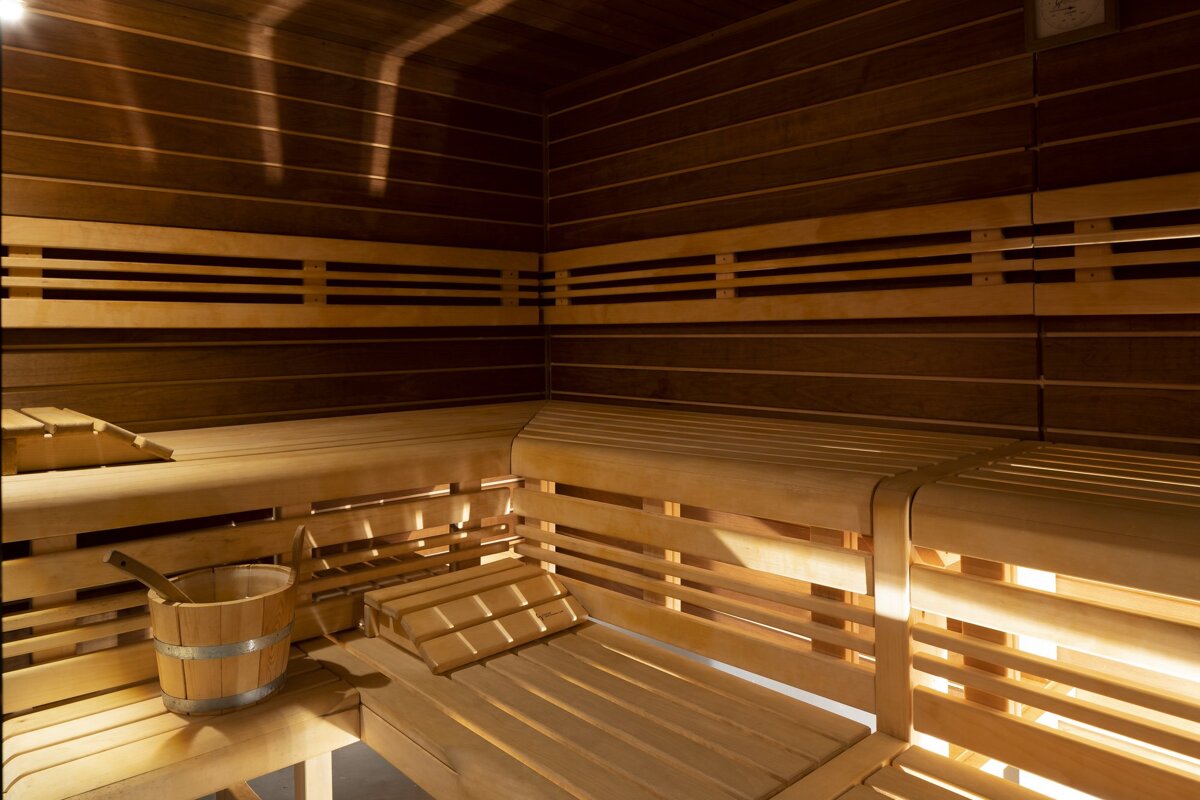 A wooden bucket sits on a wooden bench in a sauna