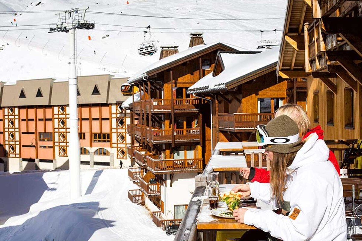 Two people sitting at a table in front of a building that says ' esprit ' on it