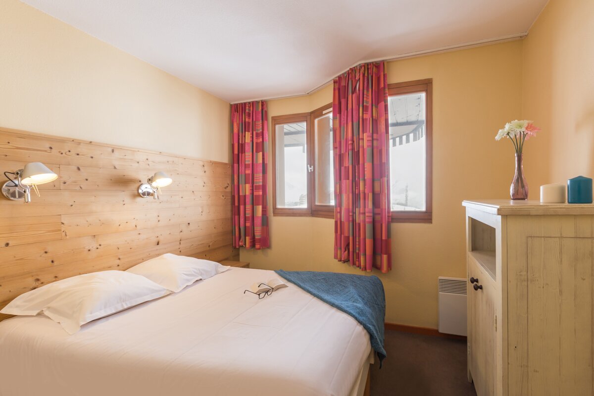 A hotel room with a bed and a window