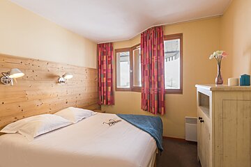 A hotel room with a bed and a window