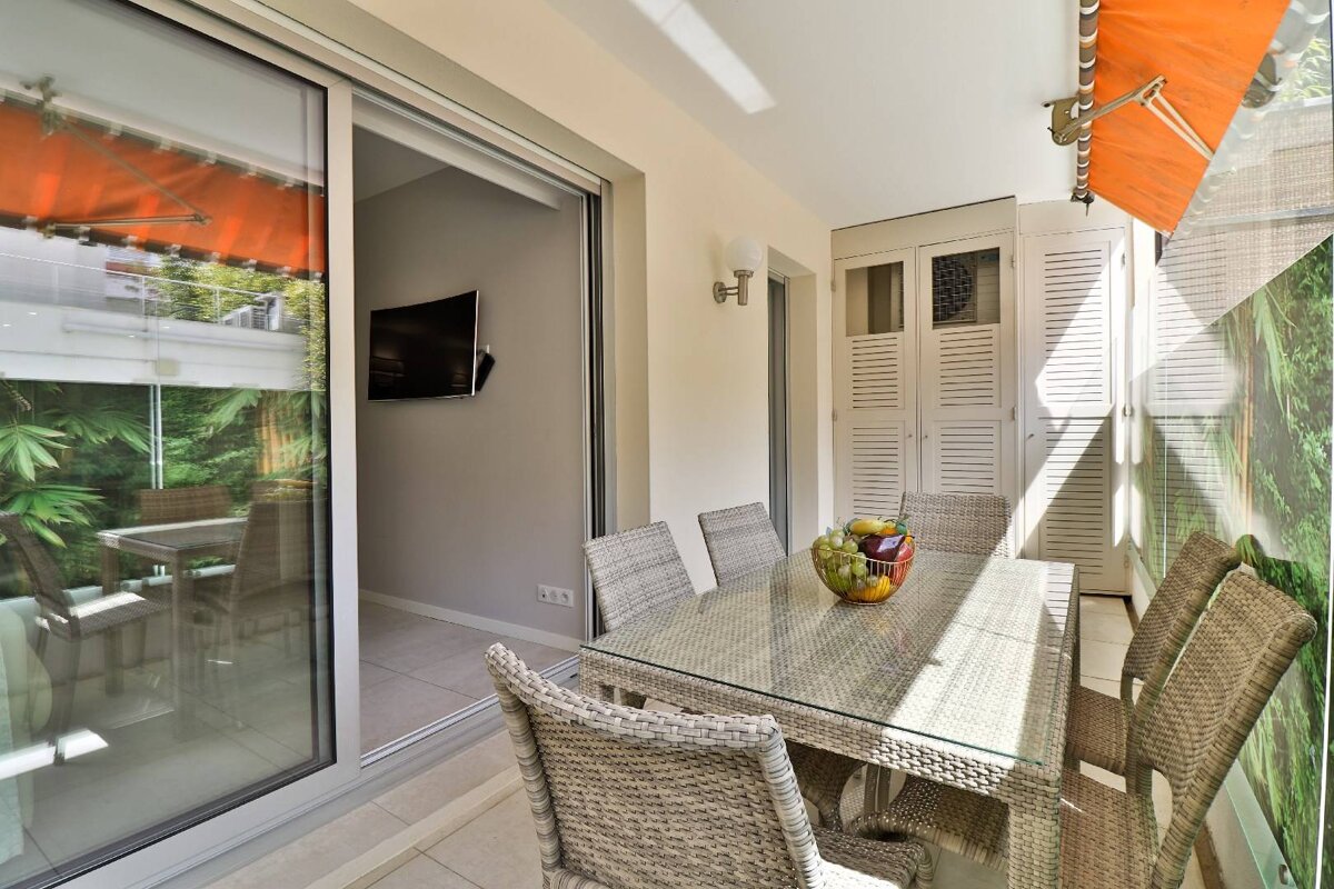 A patio with a table and chairs and a television