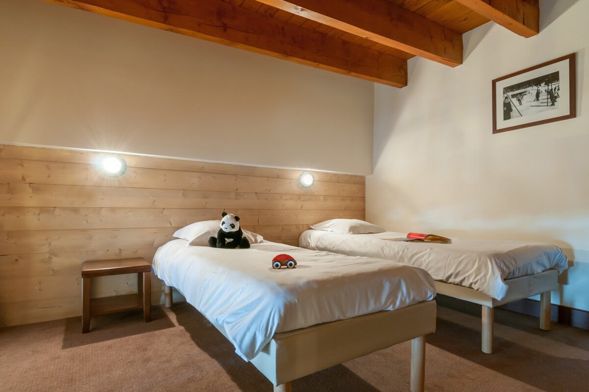 A bedroom with two beds and a picture on the wall