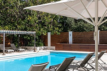 A swimming pool with chairs and umbrellas around it