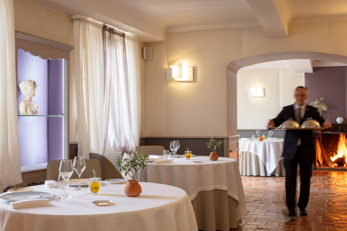 A man in a suit and tie stands in a dining room