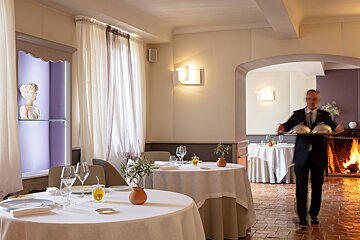 A man in a suit and tie stands in a dining room