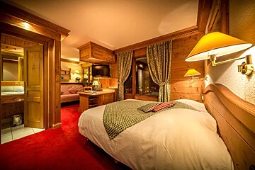 A hotel room with a bed and a desk