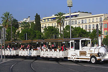 A white and gold train is going down the tracks