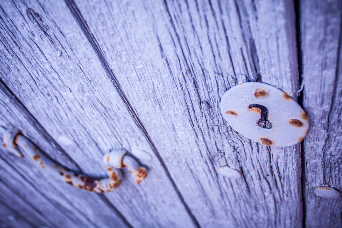 a blue painted door with rusty keyhole