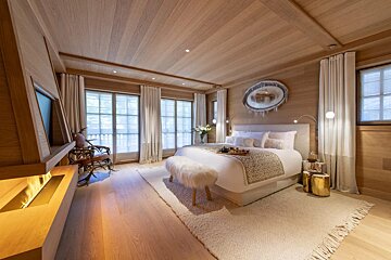 A bedroom with a large bed and a fireplace