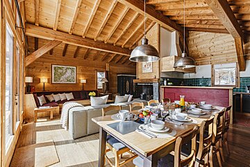 A wooden house with a dining table and chairs