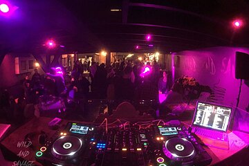 The word savage is on the wall behind the dj