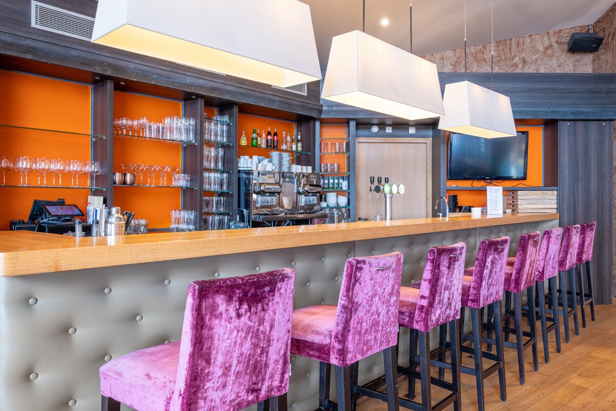 A row of purple velvet bar stools in a restaurant