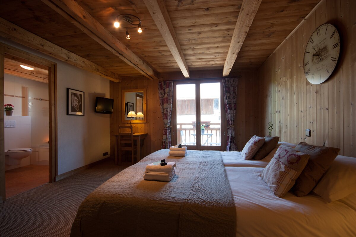 A bedroom with two beds and a clock on the wall