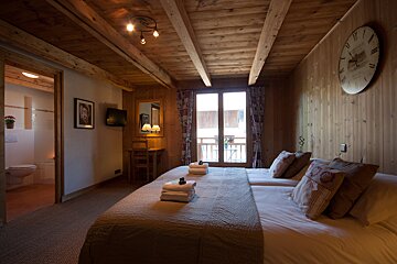 A bedroom with two beds and a clock on the wall