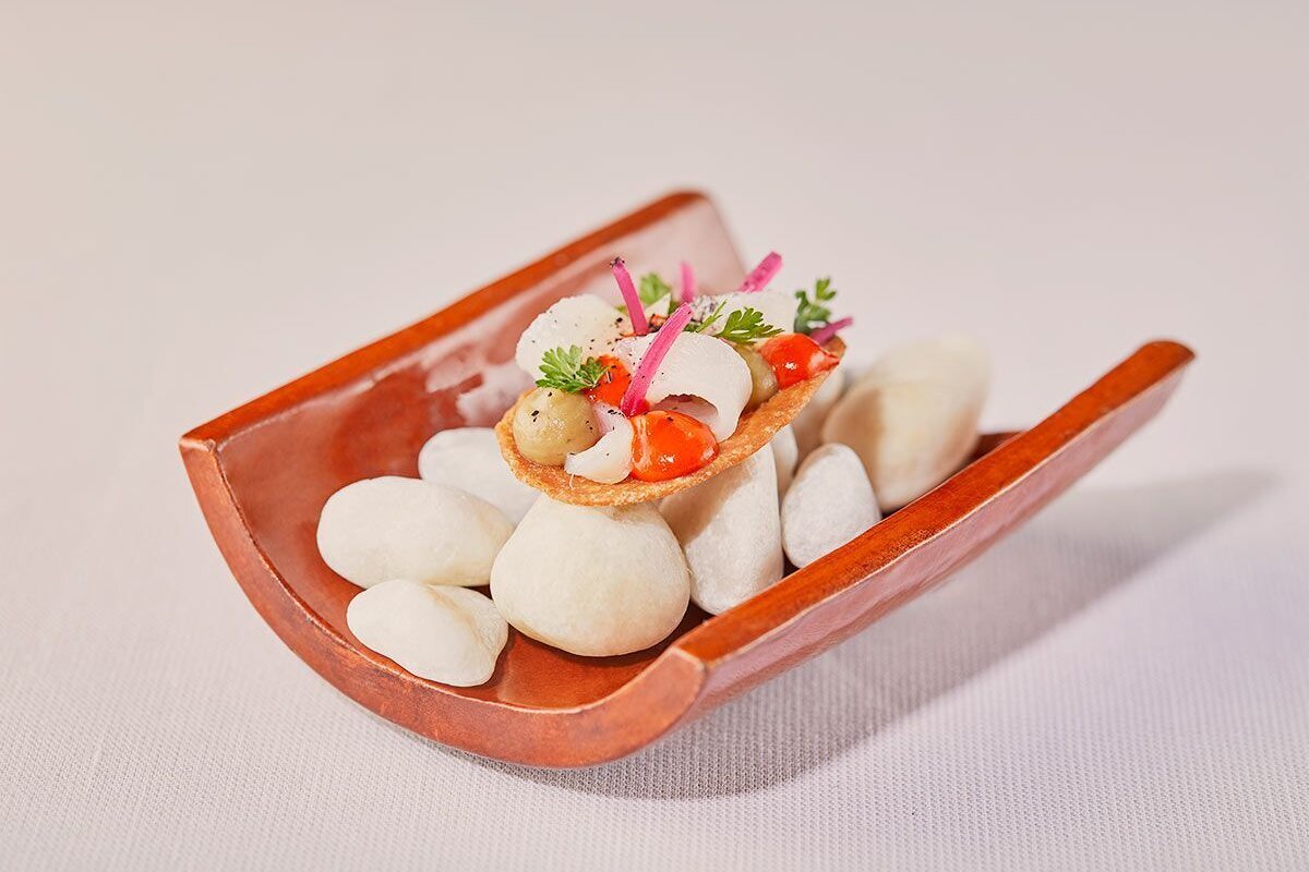 A wooden bowl filled with white rocks and food