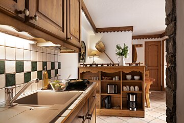 A kitchen with wooden cabinets and a coffee maker