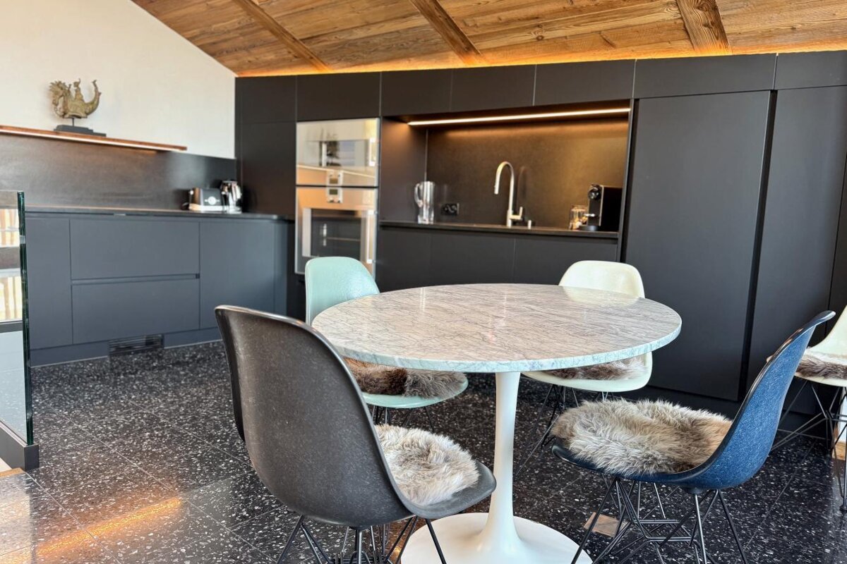 A kitchen with a table and chairs in it