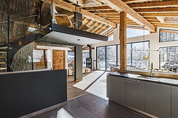 A kitchen with a staircase leading up to the second floor