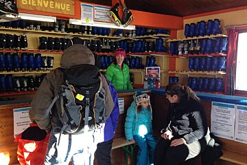 three people hiring skates in a wooden cabin