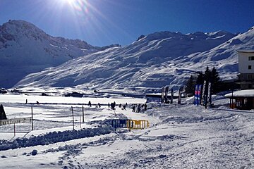 a view of mountains surrounding the frozen lake in tignes