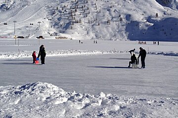 two children with parents on an ice rink