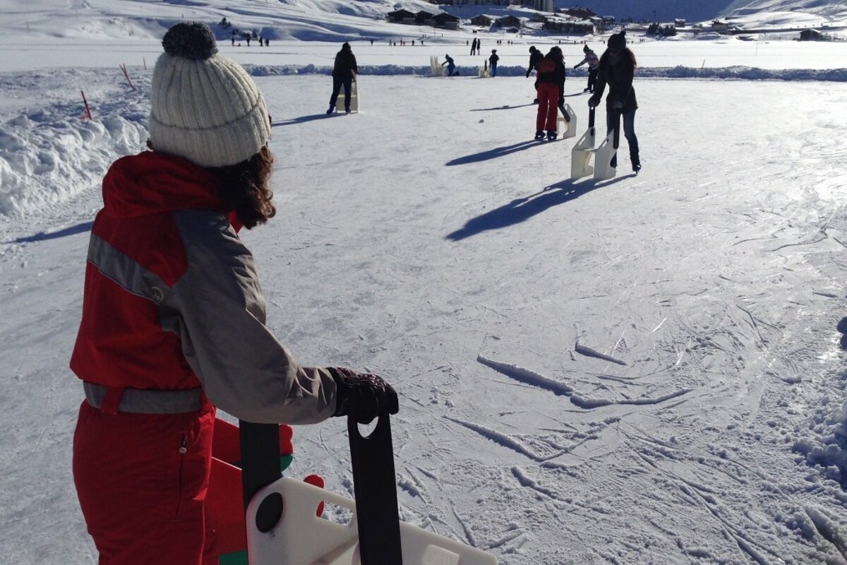 a woman in a one piece ski suit wearing a bobble hat