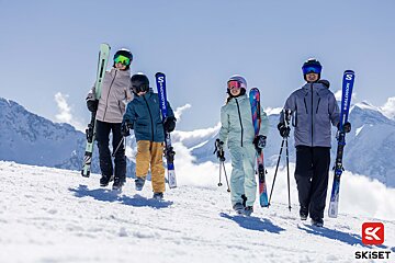 A group of people carrying skis that say salomon on them