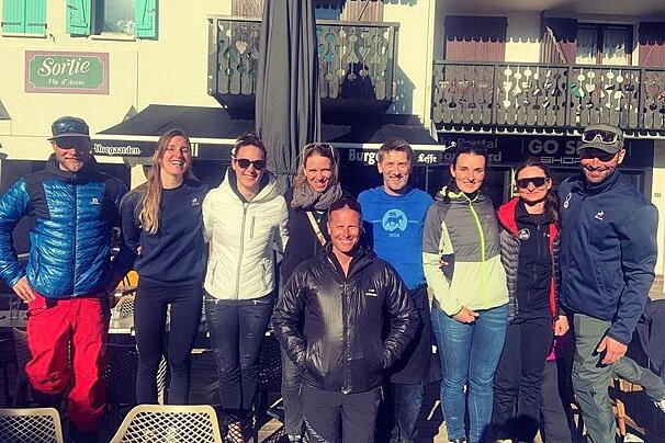 A group of people posing in front of a sign that says sortie