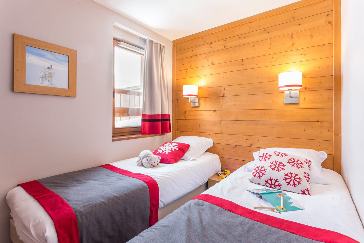 A bedroom with two beds and a picture on the wall