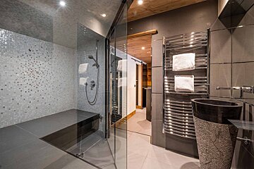 A bathroom with a walk in shower and a sink