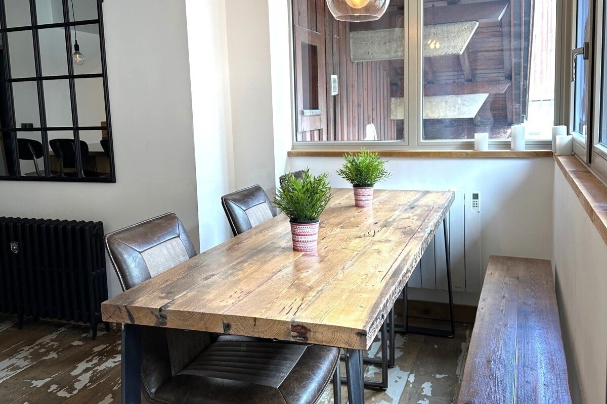 A wooden table with two potted plants on it