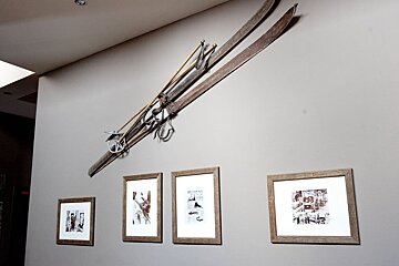 A pair of skis hanging on a wall next to some framed pictures