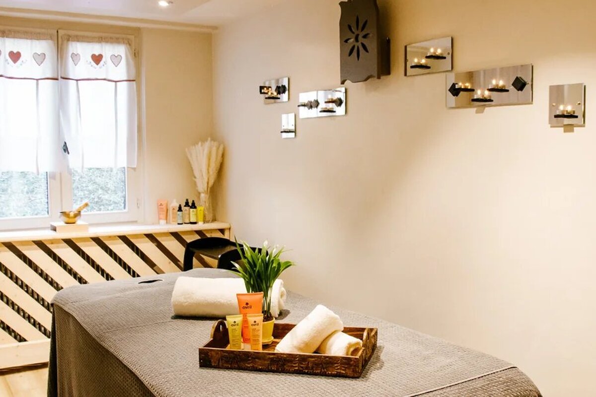 A massage table in a room with candles on the wall