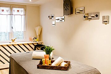 A massage table in a room with candles on the wall