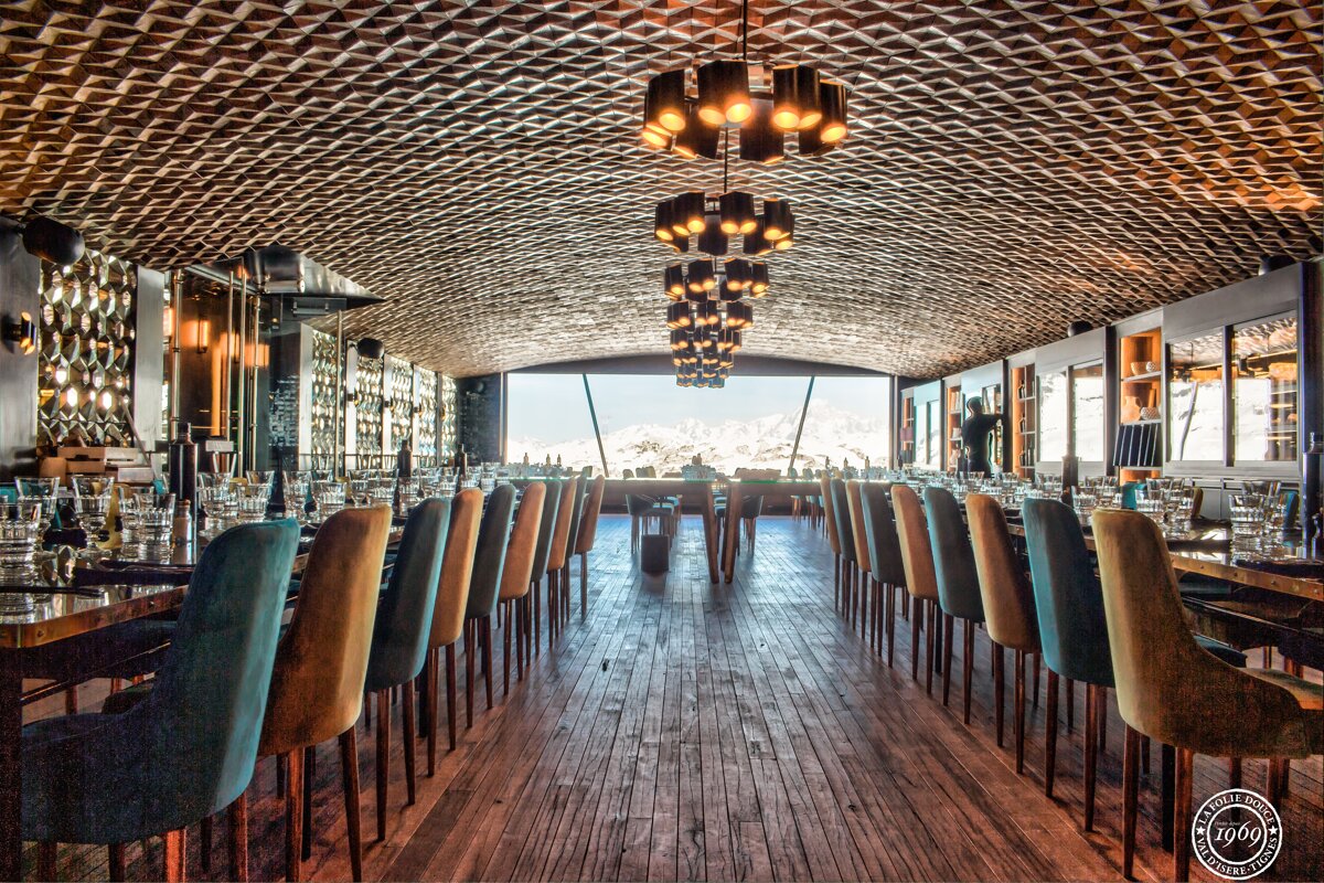 A long dining room with tables and chairs and a sign that says ' enjoy ' on it