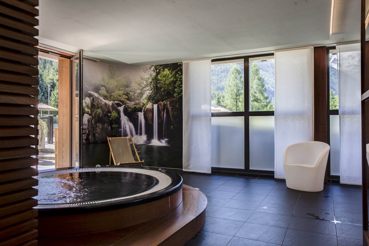A hot tub with a picture of a waterfall on the wall