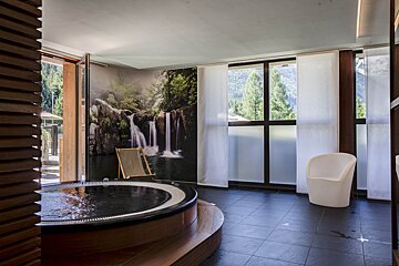 A hot tub with a picture of a waterfall on the wall
