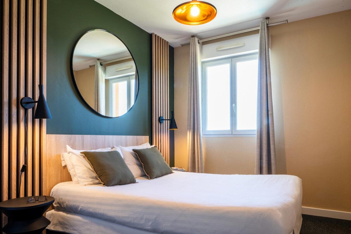 A bedroom with a bed and a mirror on the wall