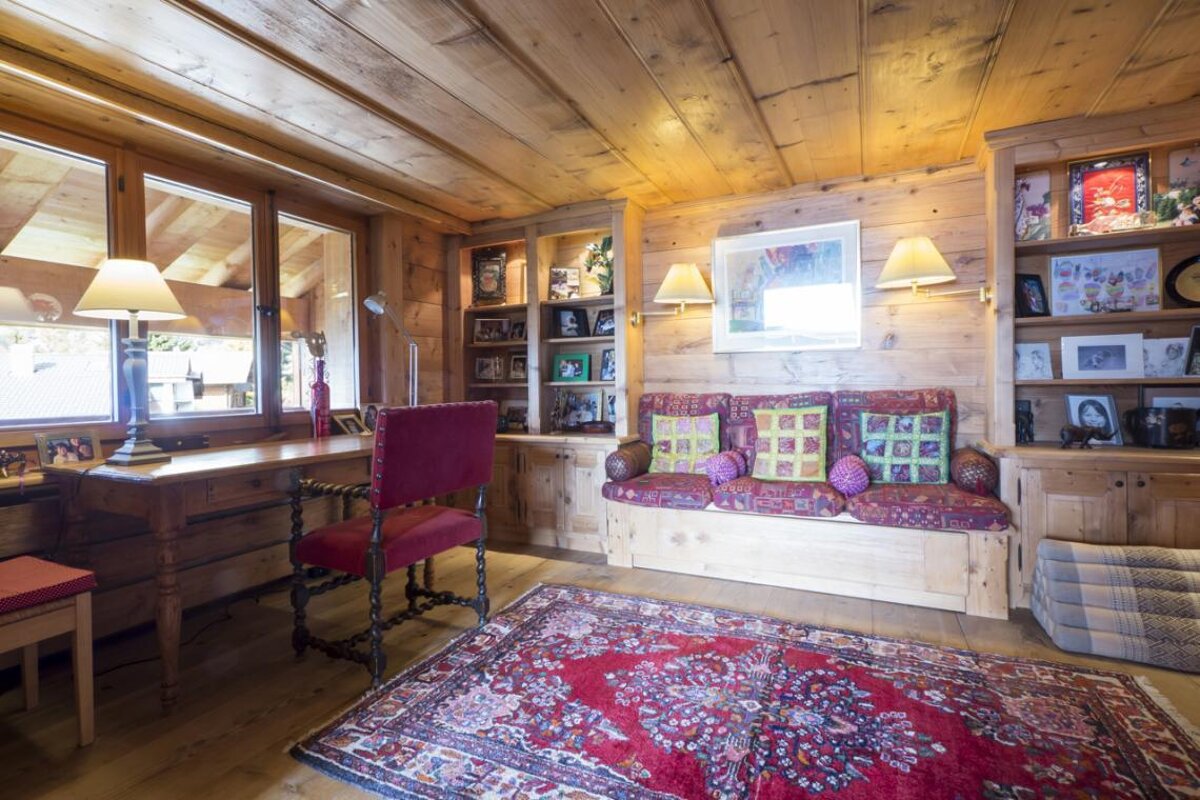 A wooden room with a couch and a rug