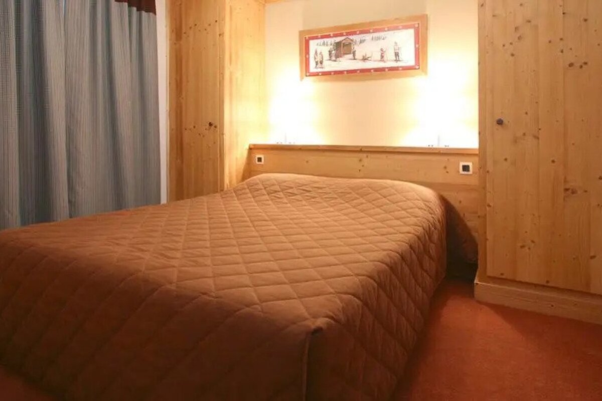 A bedroom with a bed and a picture on the wall