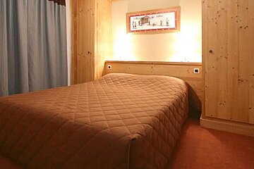 A bedroom with a bed and a picture on the wall