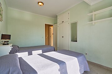 A bedroom with two beds and a mirror on the wall