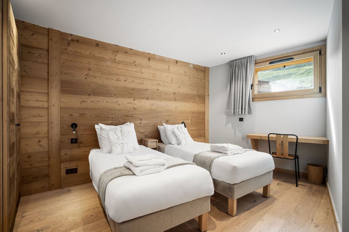 A bedroom with two twin beds and a desk